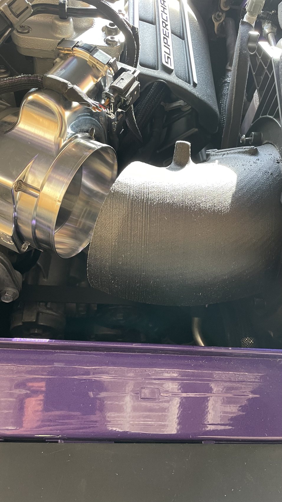 Prototype intake tube connected near the throttle body in an engine bay