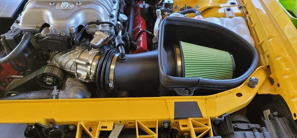 Green panel filter and intake route in a yellow car engine bay
